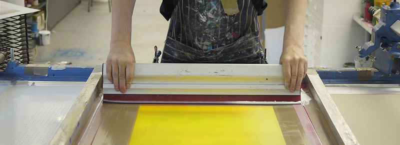 Ink being pressed through a mesh screen using a squeegee